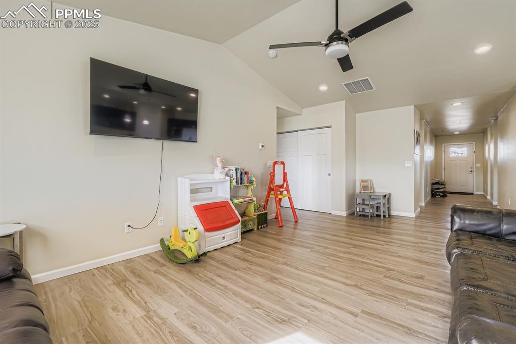 Playroom featuring light wood finished floors, a ceiling fan, and lofted ceiling