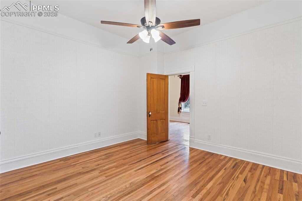 Unfurnished room featuring wood finished floors and a ceiling fan