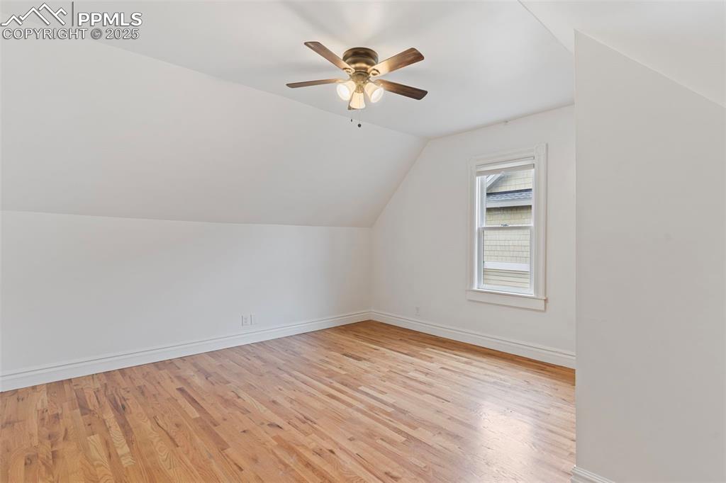 Bonus room featuring vaulted ceiling, light wood finished floors, and ceiling fan