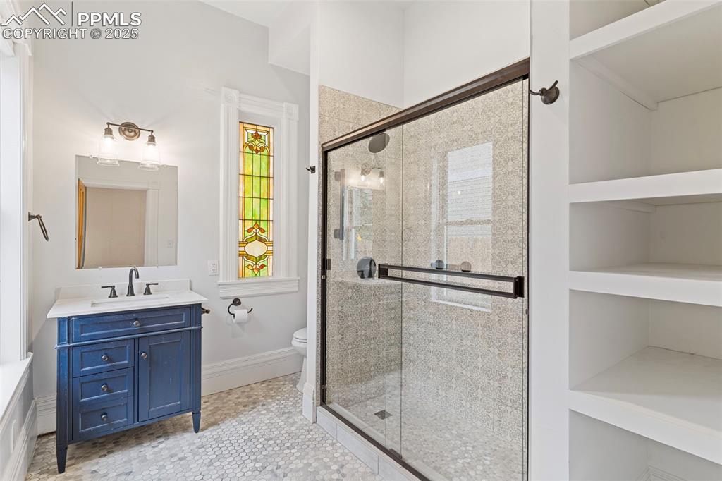 Full bathroom featuring vanity, a shower stall, and light tile patterned floors