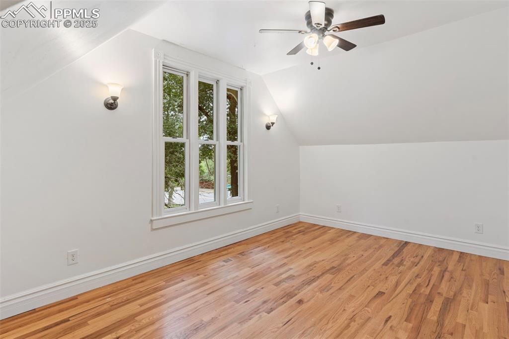 Bonus room featuring lofted ceiling, light wood-style flooring, and ceiling fan