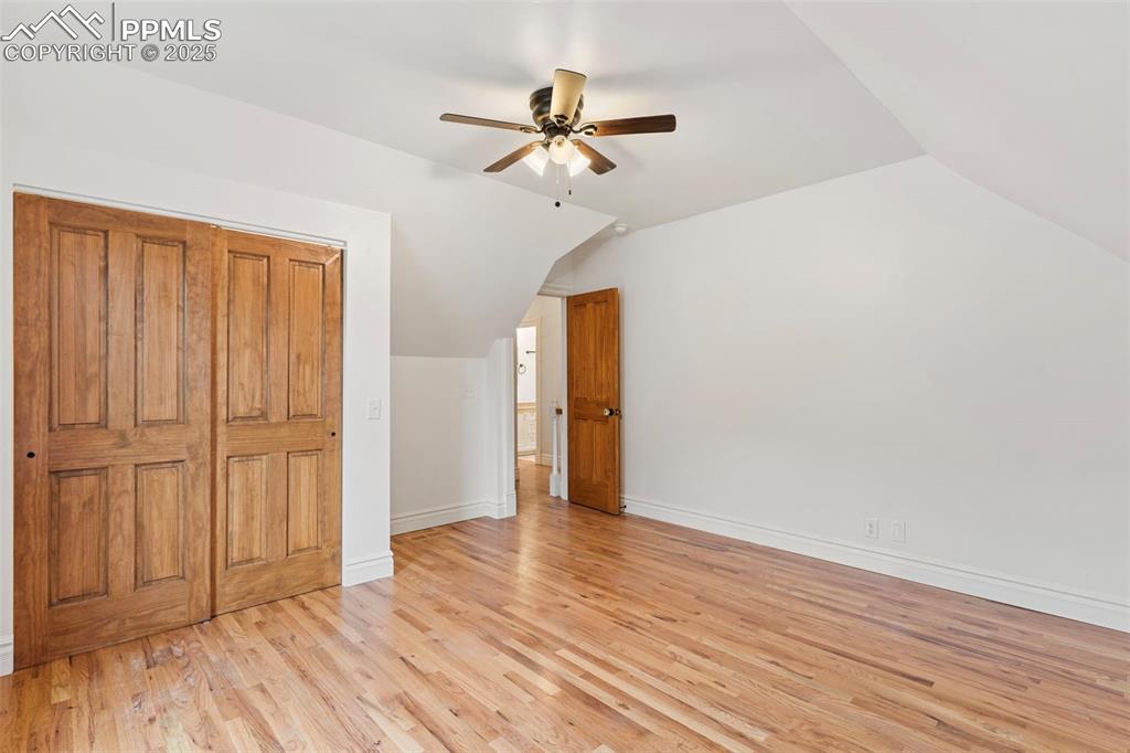 Bonus room featuring vaulted ceiling, light wood finished floors, and ceiling fan