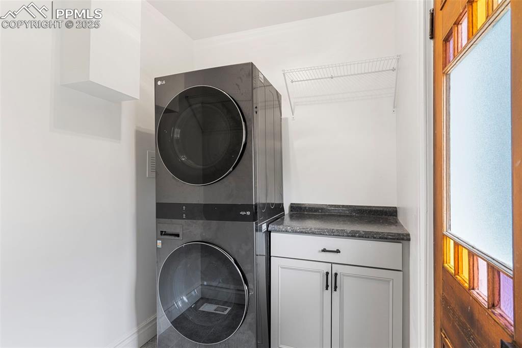 Laundry room with estacked washer and dryer and cabinet space