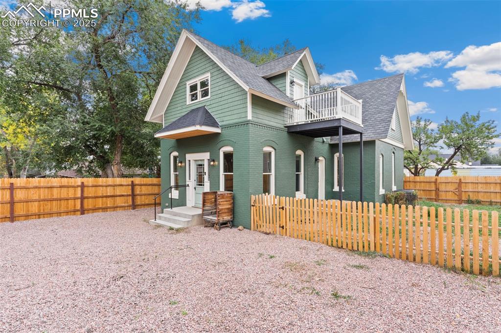 View of front of house with a shingled roof and brick siding