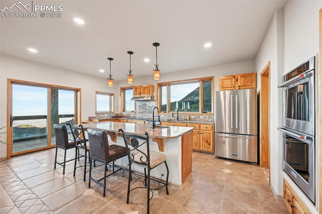 Open concept kitchen with a walk out, granite countertops, an island with breakfast bar and matching stainless appliances
