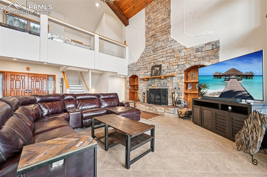 Living room with walk and out wood burning fireplace all surrounded by 27 ft ceilings