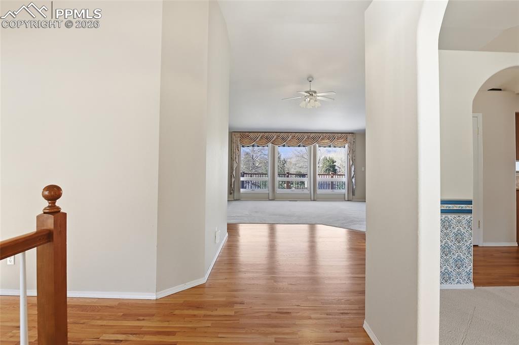 Corridor featuring light wood-type flooring and arched walkways