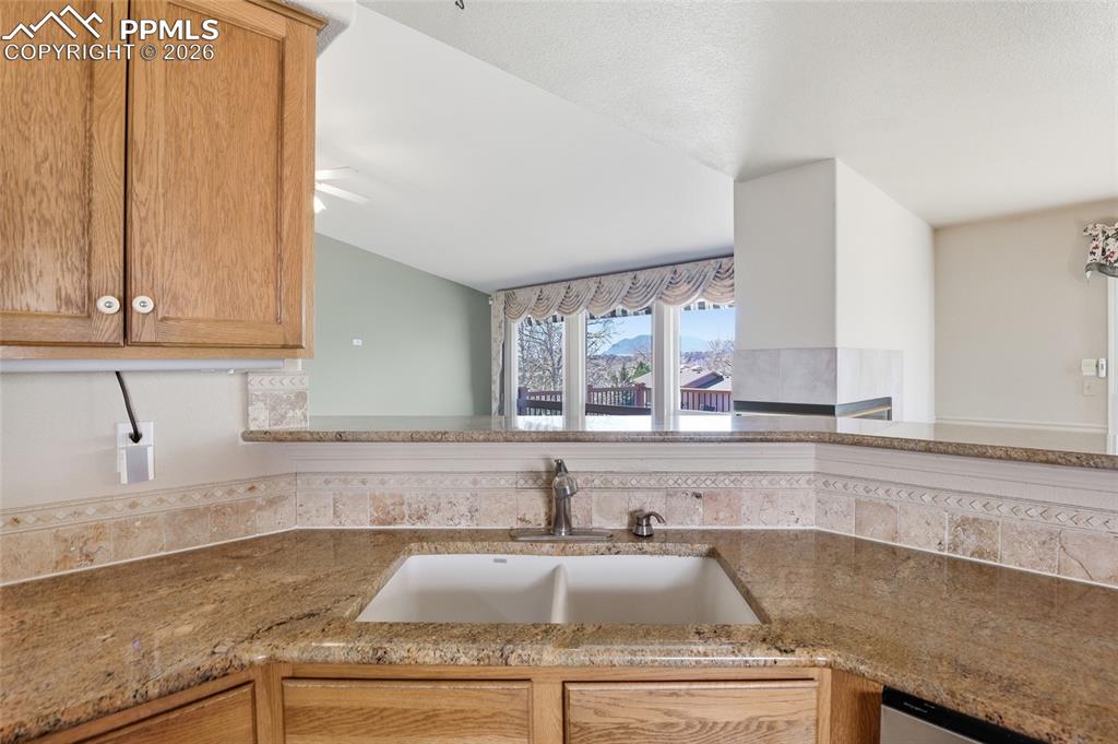 Kitchen featuring light stone counters and a sink