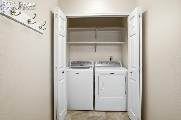 Laundry area with washing machine and dryer and a textured wall
