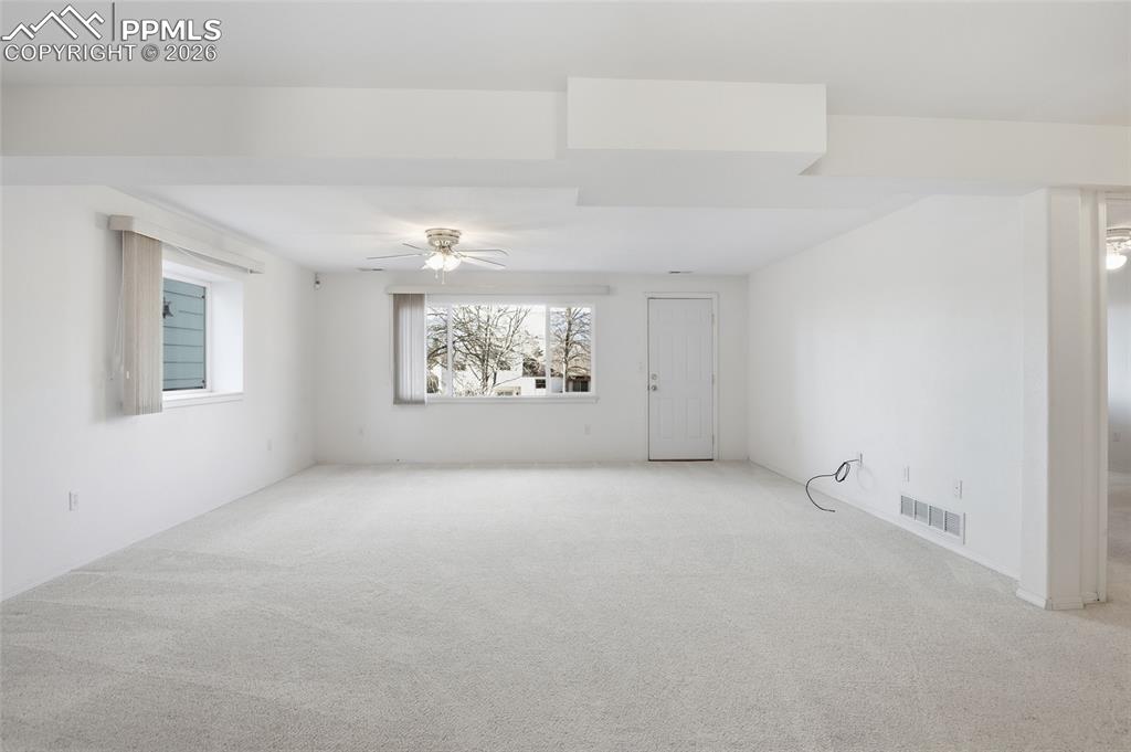 Unfurnished room with light colored carpet and ceiling fan