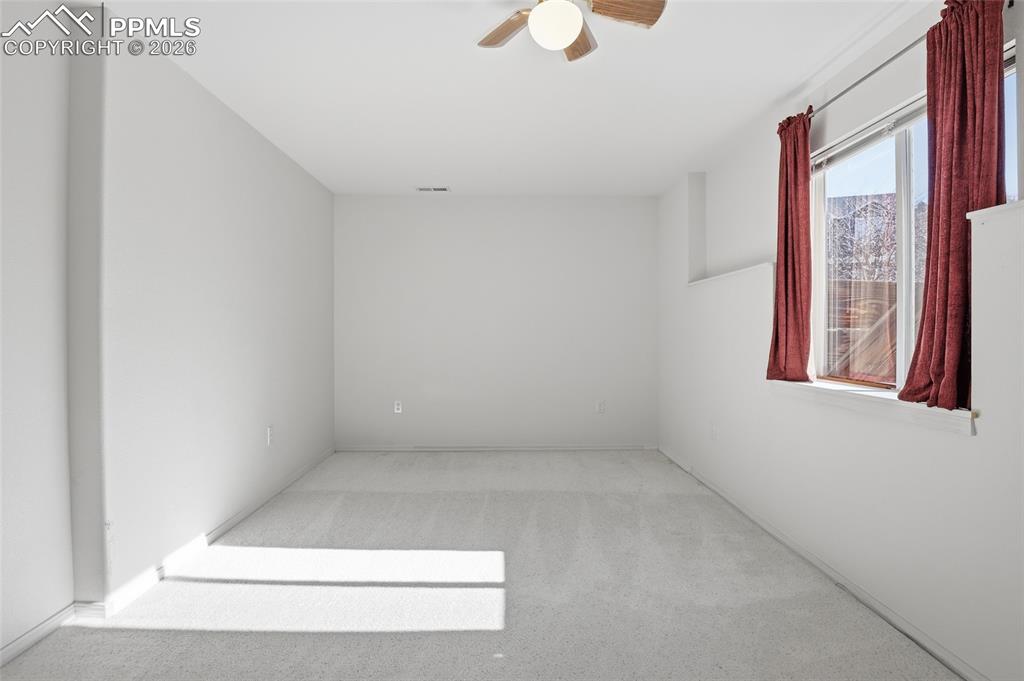 Unfurnished room with light carpet and ceiling fan
