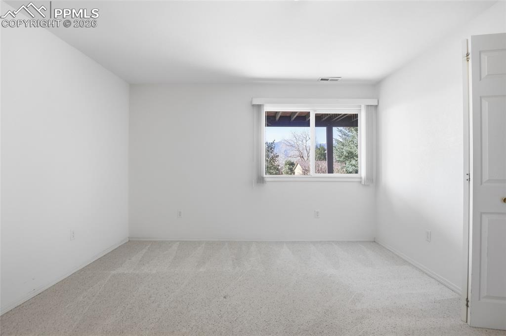 Unfurnished room with light colored carpet and baseboards