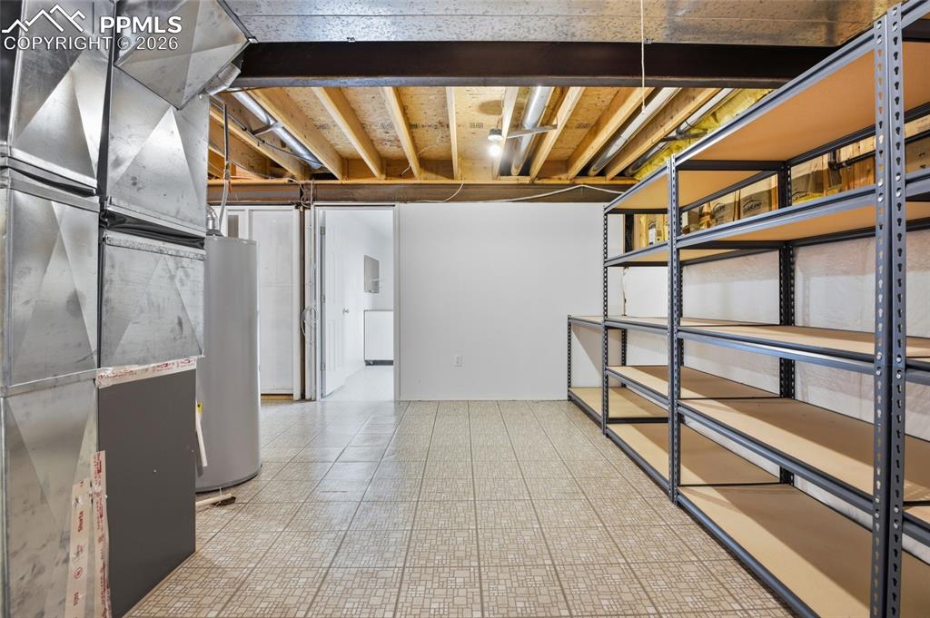 Unfinished basement featuring water heater and heating unit