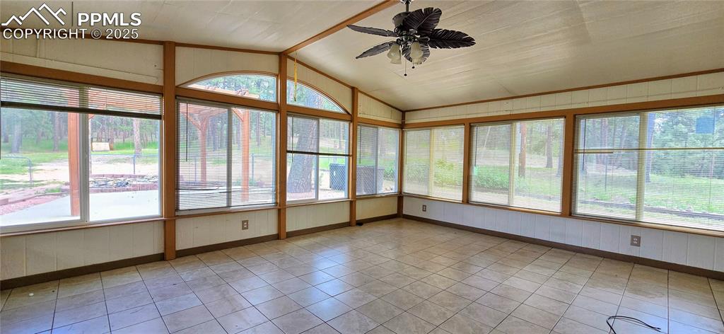 Unfurnished sunroom featuring wooden walls