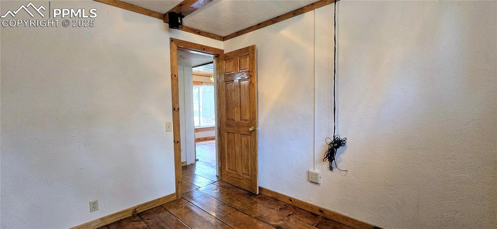 Unfurnished room with dark wood finished floors and baseboards