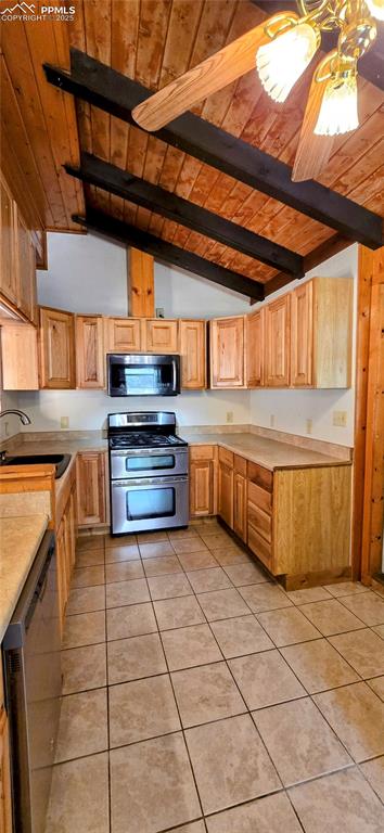 Kitchen featuring wood ceiling, light tile patterned flooring, stainless steel appliances, light countertops, and light brown cabinetry