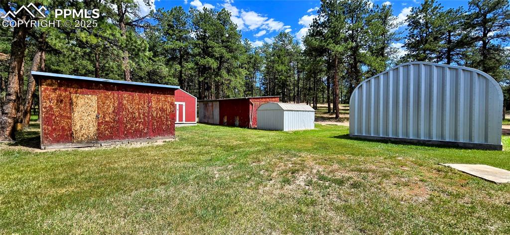 View of green lawn featuring a shed