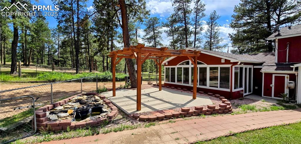 View of patio / terrace with a pergola, a sunroom, and a fire pit
