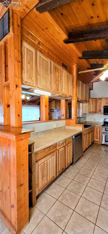 Kitchen featuring light tile patterned floors, light countertops, stainless steel appliances, and wood ceiling