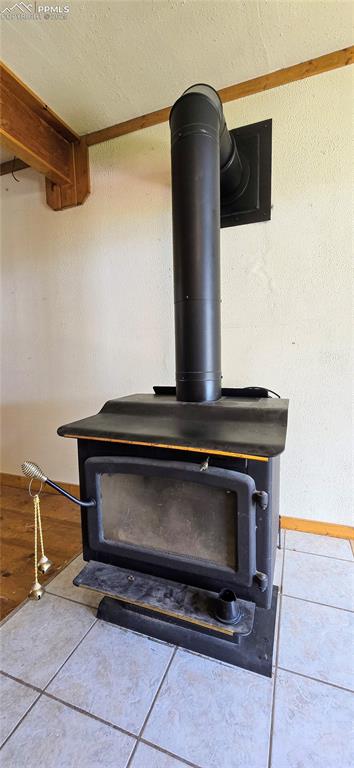 Detailed view of a wood stove, a textured ceiling, and ornamental molding