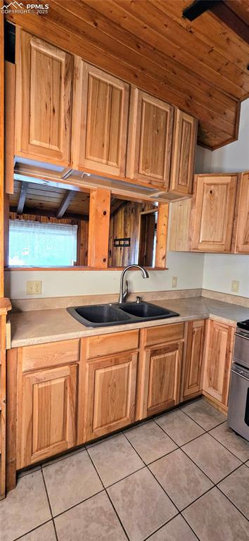 Kitchen with light tile patterned floors, range, and light countertops