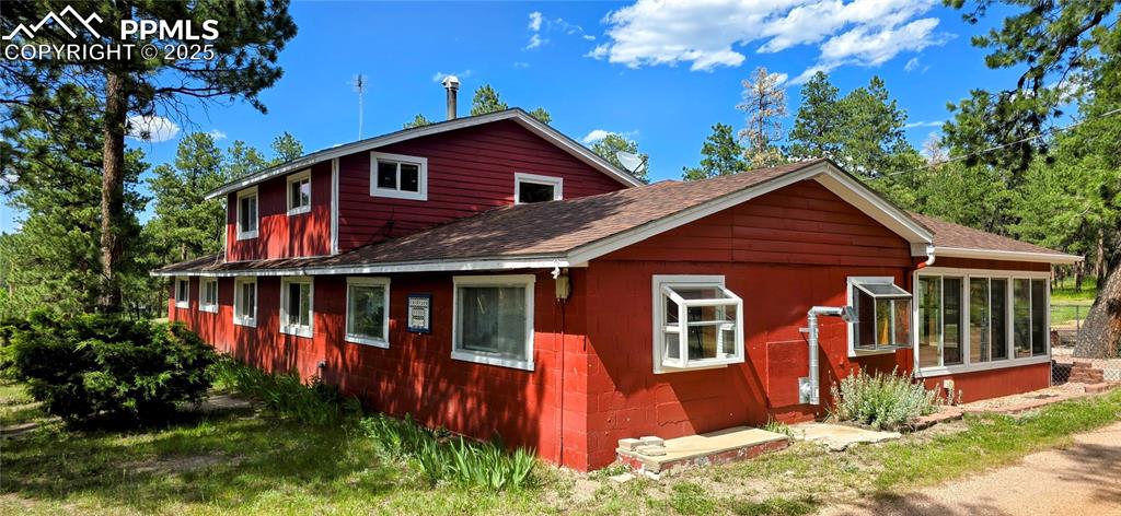 View of home's exterior featuring roof with shingles and concrete block siding