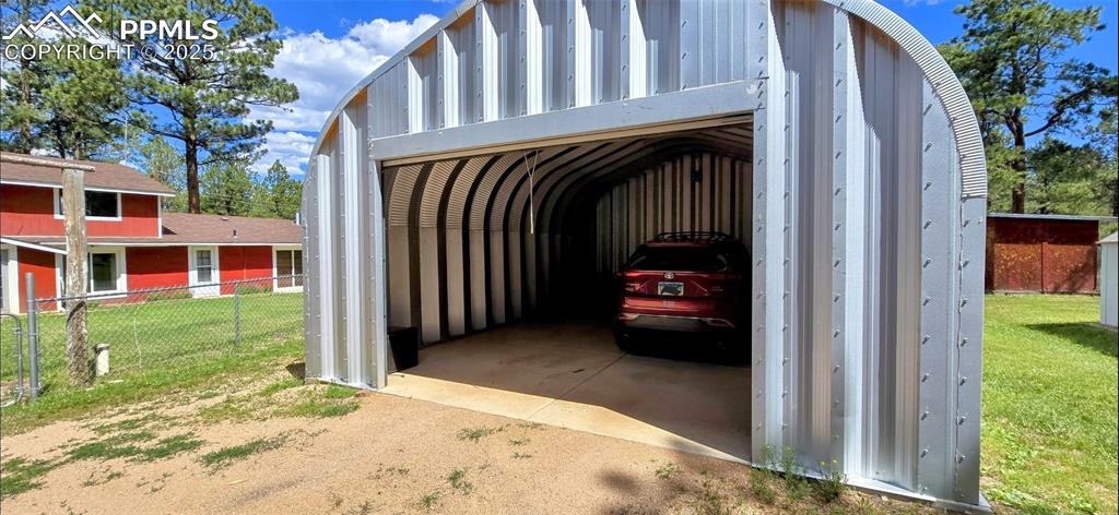 View of parking / parking lot with driveway and a garage