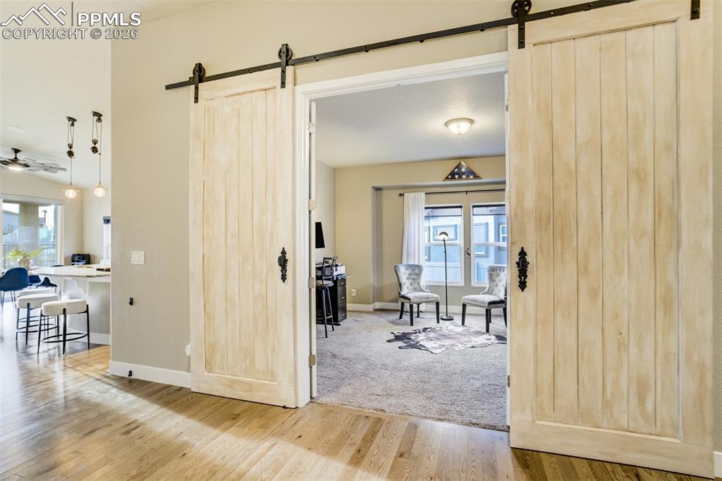 Dual barn doors lead to a formal dining area or office