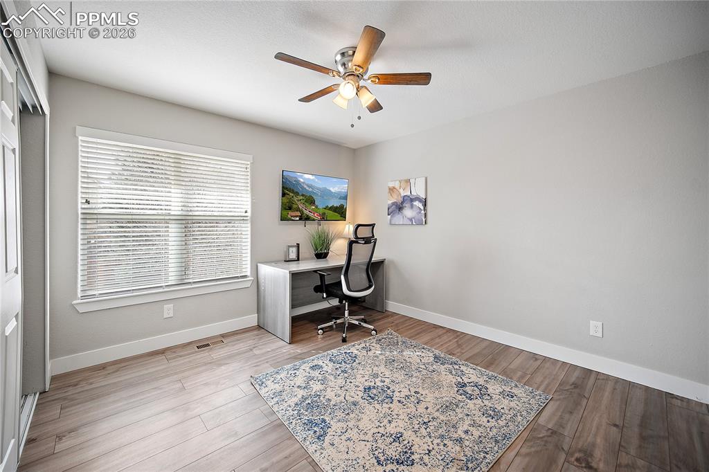 Upstairs bedroom with laminate flooring. Currently being used as an office. 