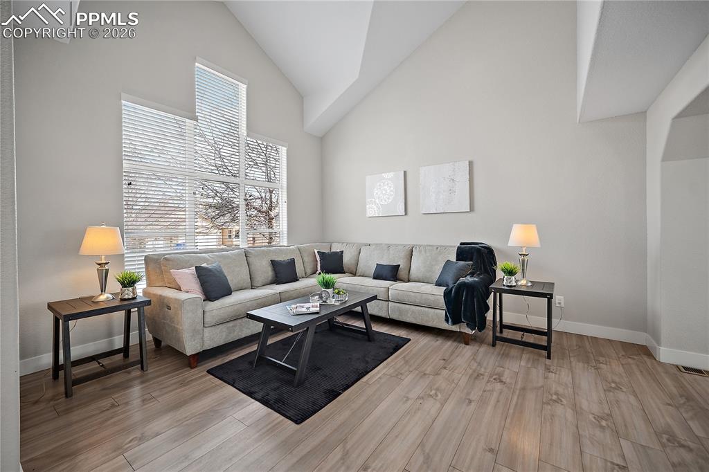 Formal living room with laminate flooring, vaulted ceilings and tons of natural light. 