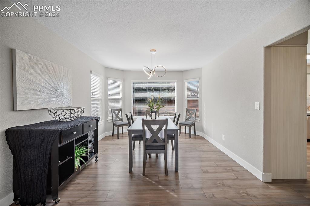 Formal dining room with bay windows. Laminate flooring continues throughout the main level. 