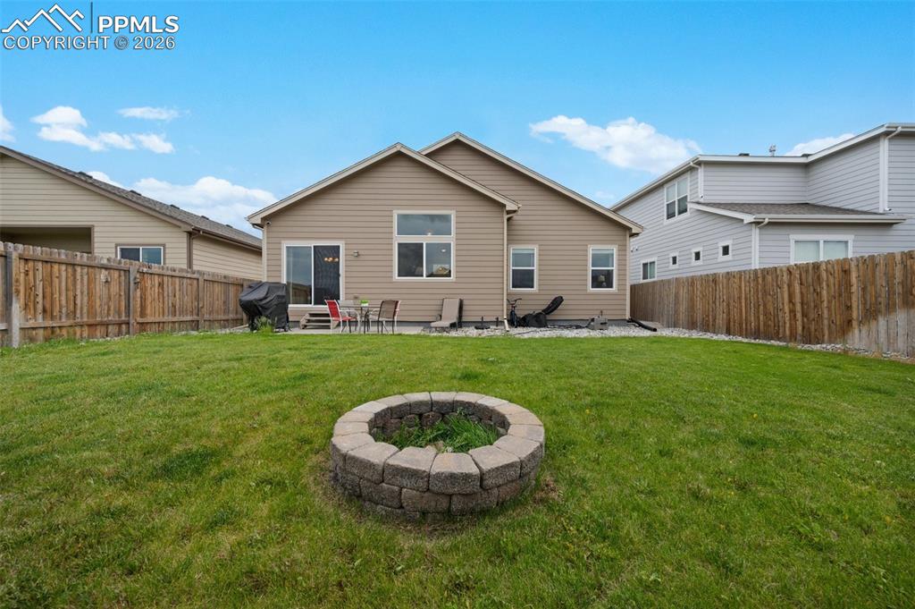 Rear view of property featuring a fire pit and patio area