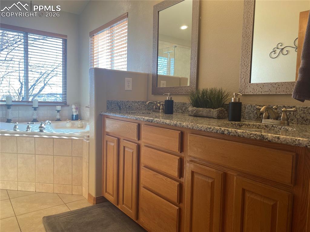 The updated master bath features granite countertops, contemporary lighting upgrades, and elegant finishes for a refreshed, spa-like ensuite experience