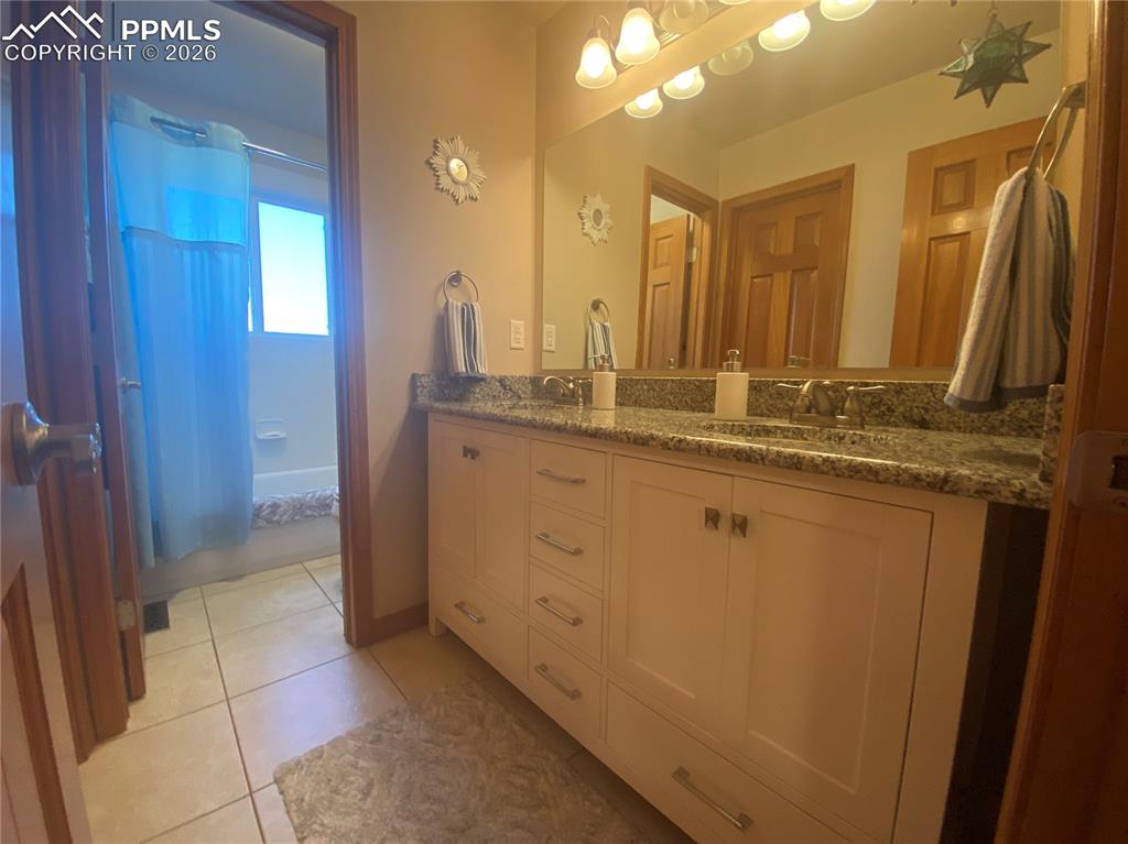 This full bathroom features granite countertops and a thoughtful dual-space layout for privacy and easy sharing, combining style with functional design