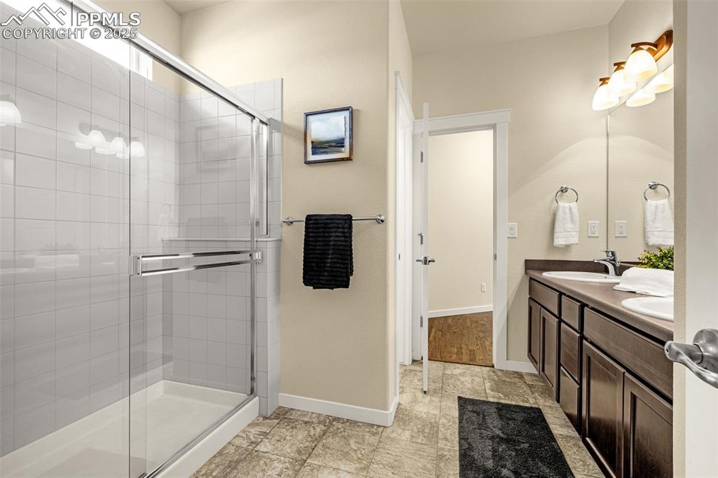 Bathroom featuring double vanity and a shower stall