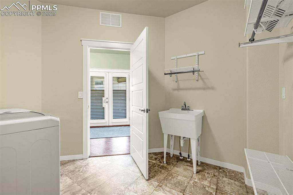 Laundry room with baseboards and french doors