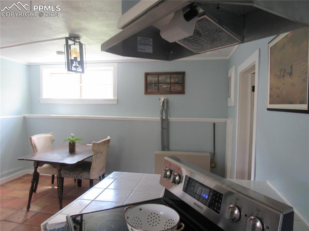 Tiled dining space featuring crown molding