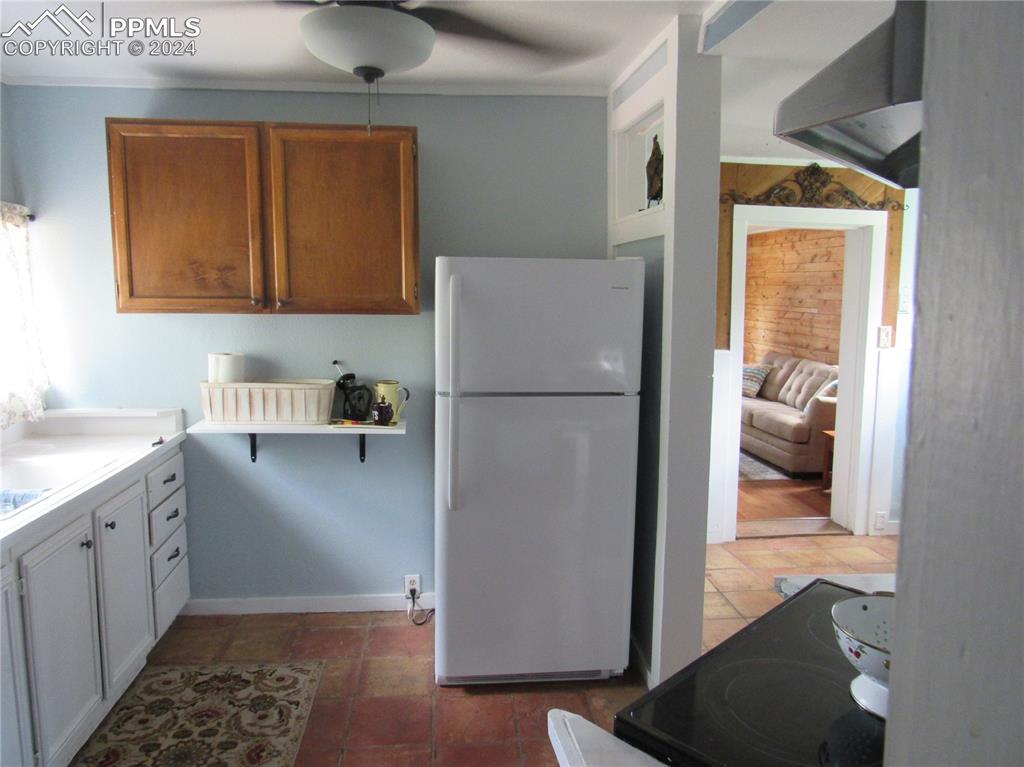 Kitchen with range, ceiling fan, and white refrigerator