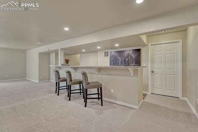 Basement bar area leading into the utility/storage space