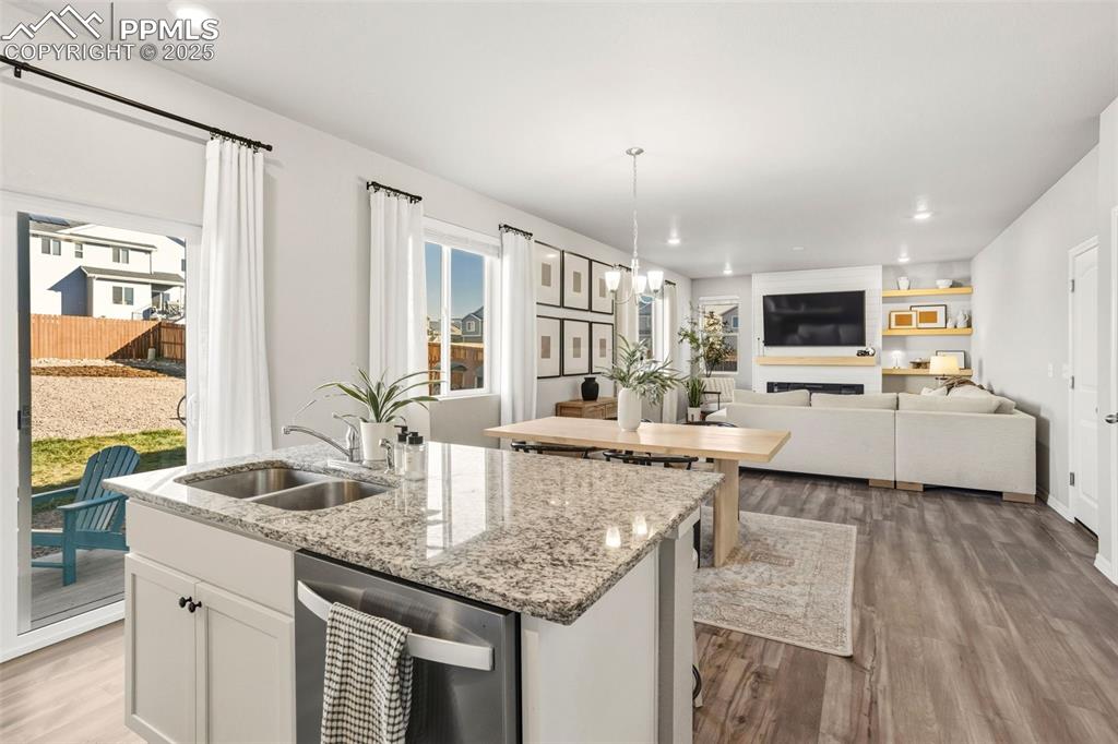 Kitchen featuring recessed lighting, stainless steel dishwasher, white cabinets, dark wood-style floors, and light stone countertops