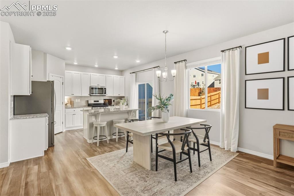 Dining area featuring light wood-style floors, a chandelier, and recessed lighting