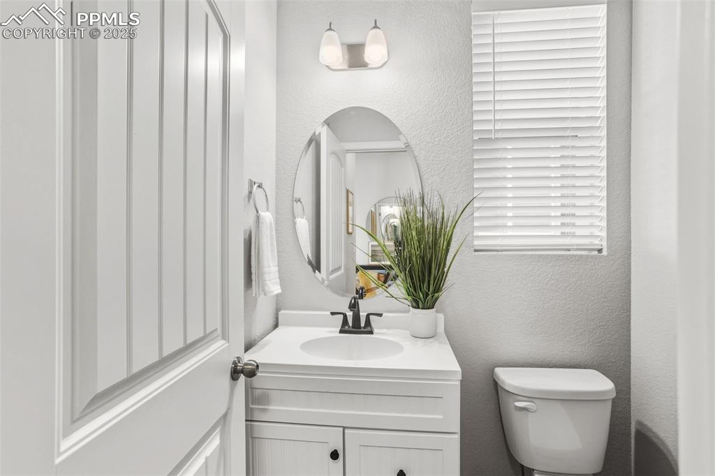 Bathroom featuring a textured wall and vanity