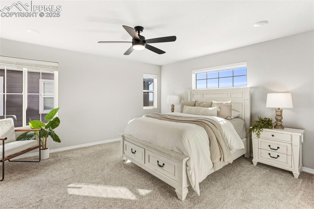 Bedroom with light carpet and a ceiling fan