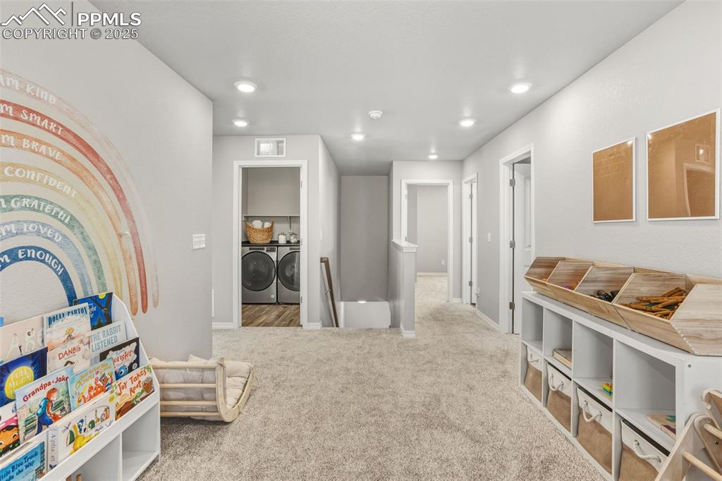 Recreation room featuring separate washer and dryer, light colored carpet, and recessed lighting