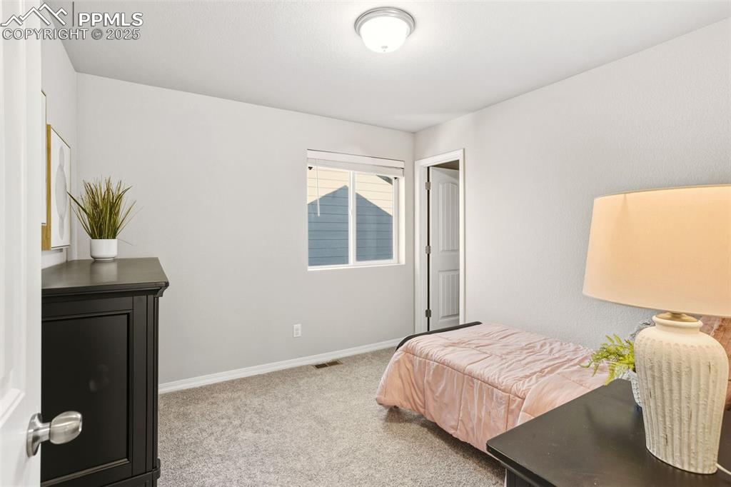 Bedroom featuring light colored carpet and baseboards