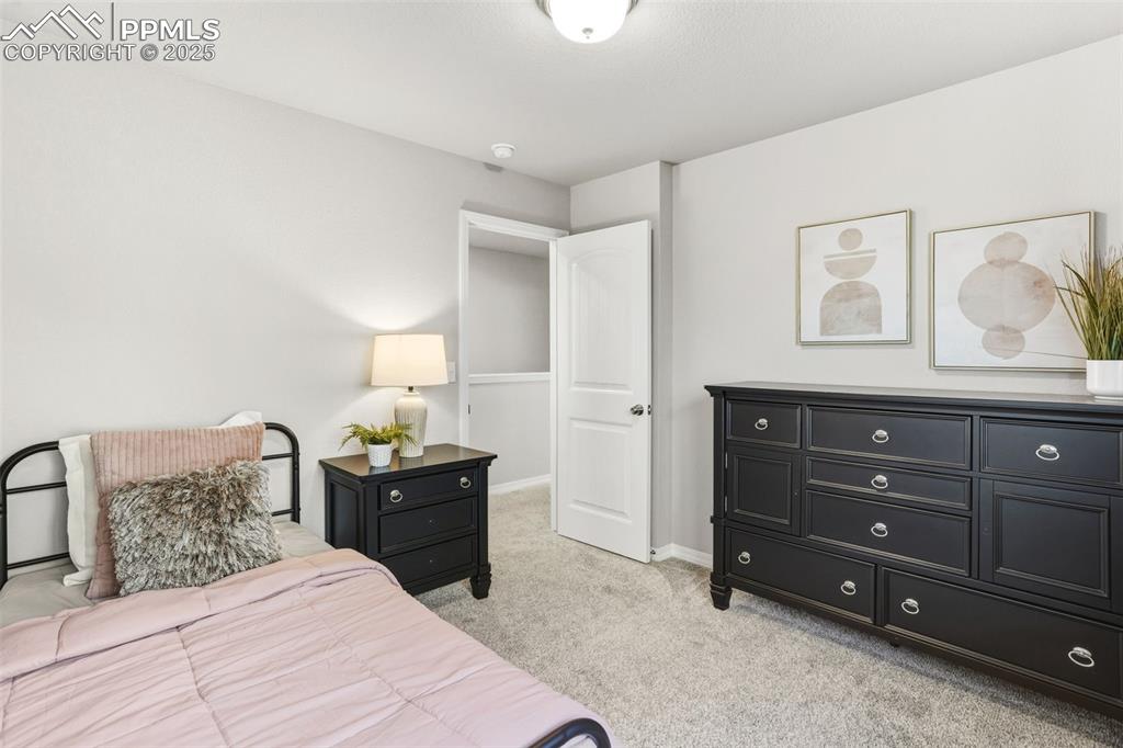 Bedroom featuring light carpet and baseboards