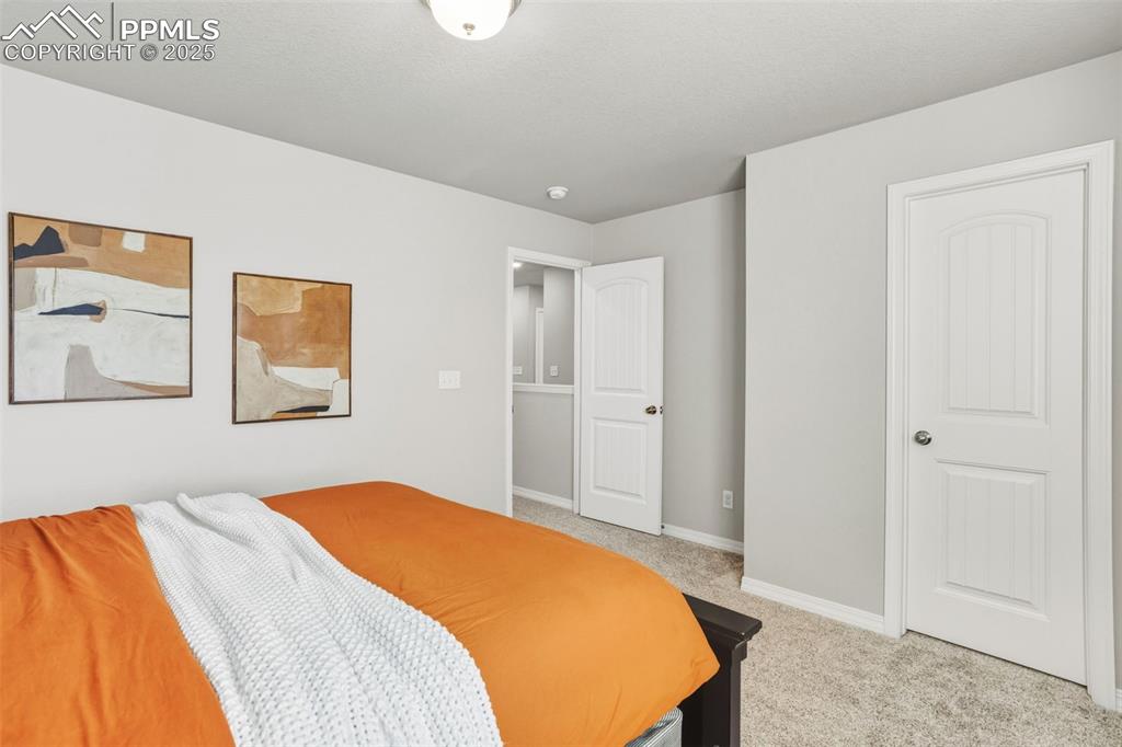 Bedroom featuring baseboards and light carpet
