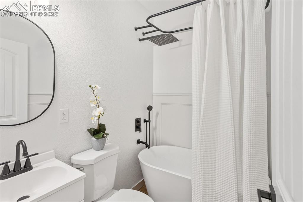 Bathroom with a textured wall and vanity