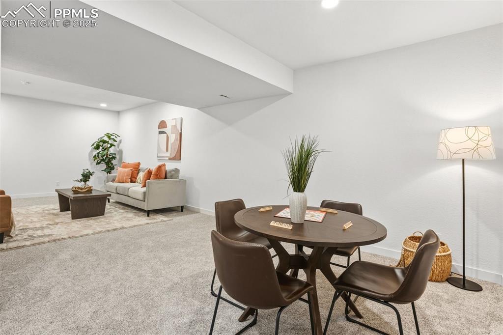 Dining area with light carpet and recessed lighting