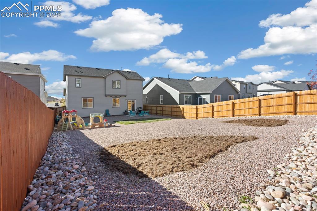 Rear view of house featuring a fenced backyard, a residential view, a patio, and a playground